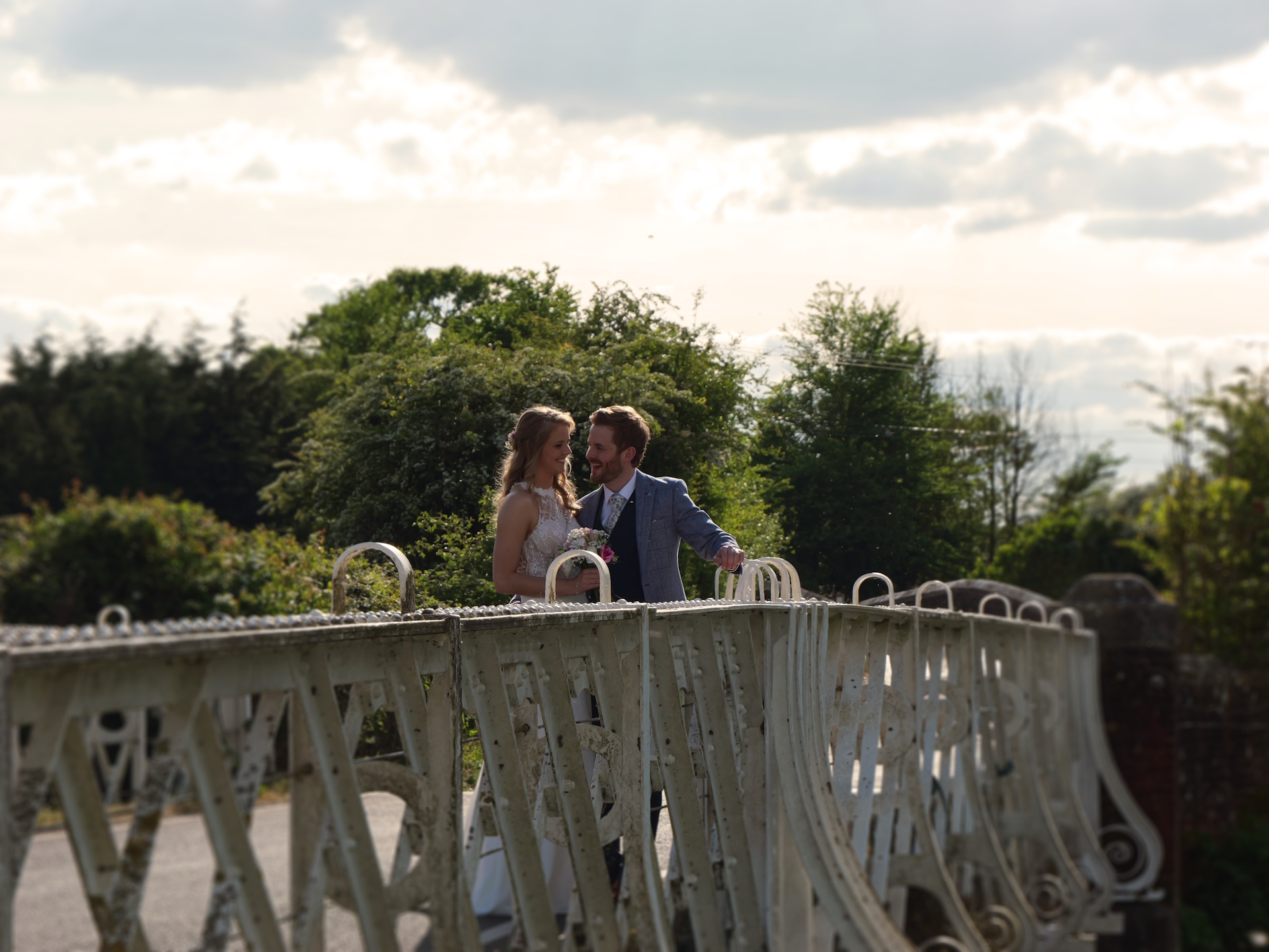 Sophie and Tom stand on an ornate bridge.